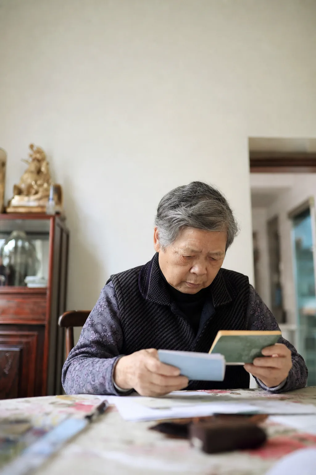 An elderly person checking assets and deposit documents at home