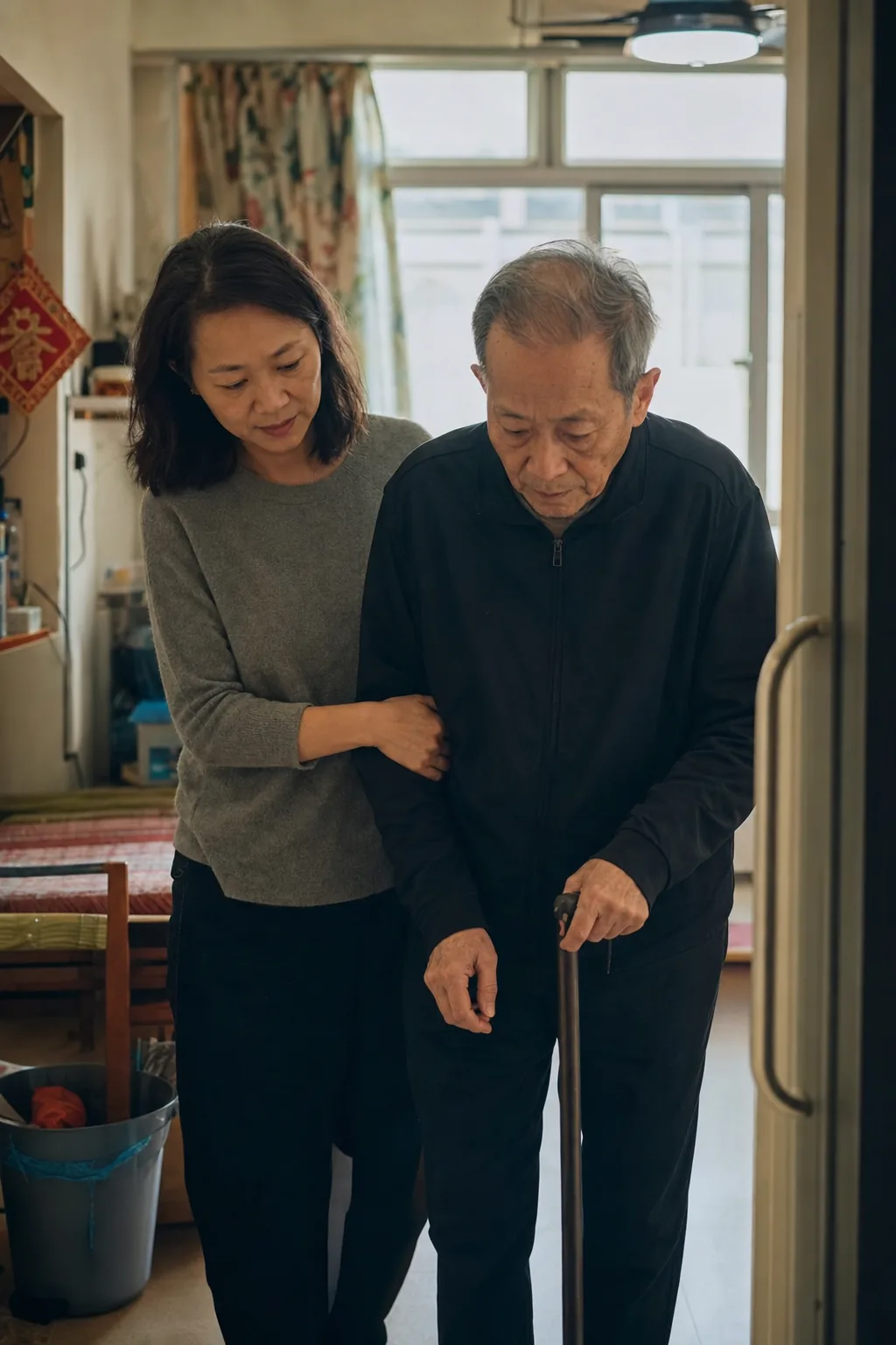 A daughter supporting her elderly father who uses a cane at home